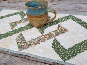 quilted table runner with a pottery mug